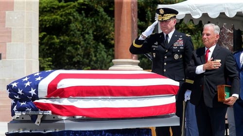US Chief of Staff of the Army, General James McConville salutes at the side of the unidentified soldier's coffin