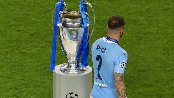Kyle Walker of Manchester City walks past the UEFA Champions League trophy after the 2021 final