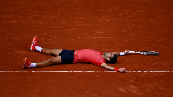 Novak Djokovic sprawled out on the ground after his match-winning point