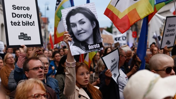 A protestor in Warsaw yesterday holds up a portrait of Dorota Lalik, who died of septic shock in her fifth month of pregnancy