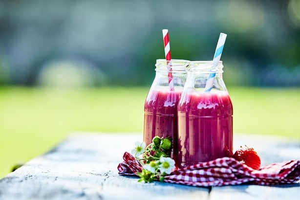 Strawberry smoothies in glass jars, outdoor summer picnic
