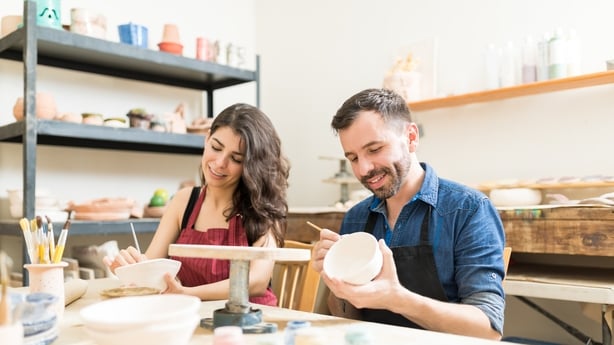 Smiling Couple Doing Creative Painting On Bowls In Pottery