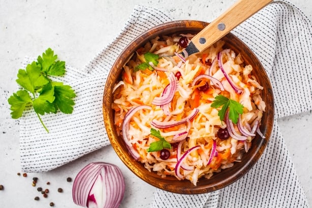 Sauerkraut with cranberries and onion in a wooden bowl