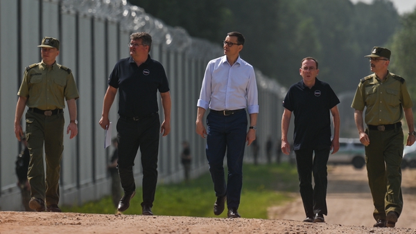Polish Prime Minister Mateusz Morawiecki (C) inspects a section of Poland's steel fence along its border with Belarus in June, 2022