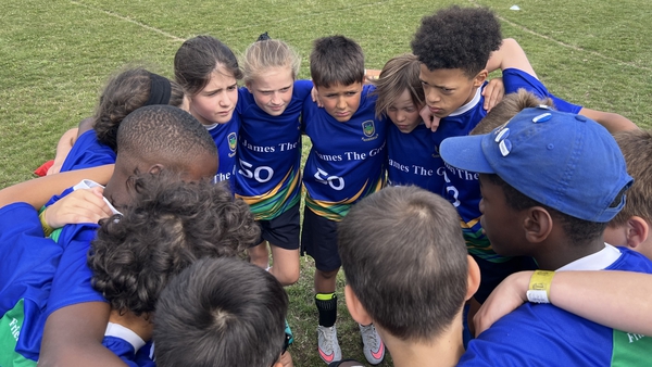Children from St James the Great School in Croydon huddle ahead of their match
