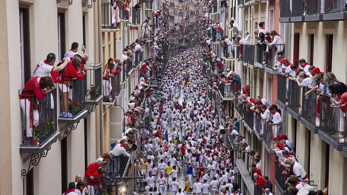 Thousands take part in bull run through streets of Spain - and