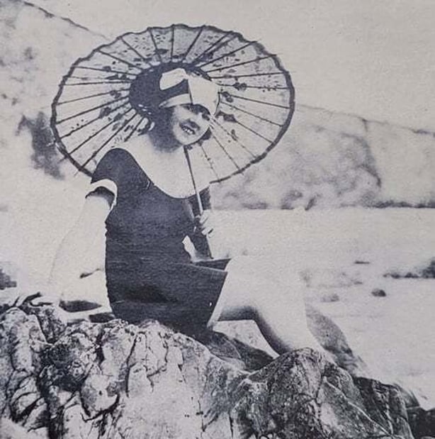 Century Ireland Issue 261 - 'The rocks at Tramore present all kinds of pleasant scenes during the summer months. Young woman on rocks with umbrella. Photo: Irish Life, August 1923