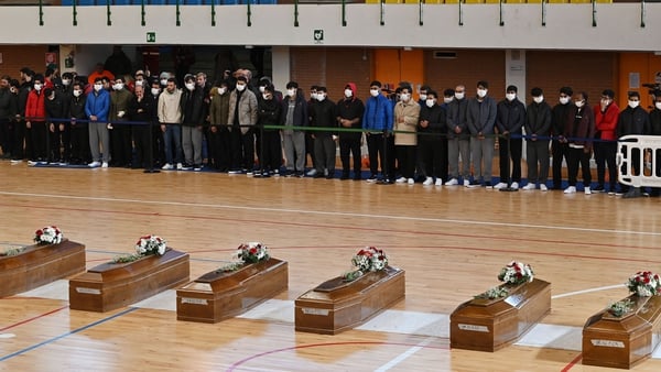 Relatives mourning by coffins of 65 victims, including 14 children, of a migrant shipwreck off Italy's southern coast in March