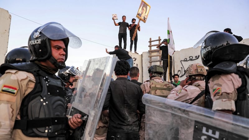 Iraqi riot police try to disperse supporters of Iraqi Shiite cleric Moqtada al-Sadr gathering for a protest outside the Swedish embassy in Baghdad