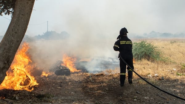 A firefighter battles a wildfire on Rhodes in Greece last July