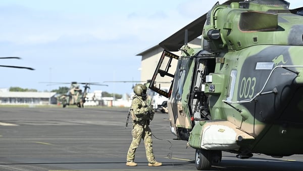 An Australian helicopter crewman is seen standing by an MRH 90 helicopter at Townsville airport on Thursday