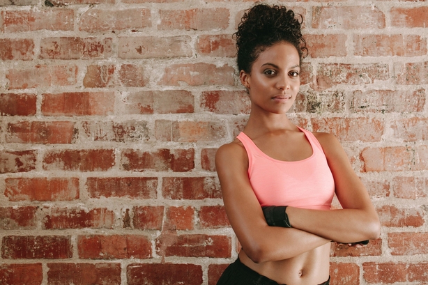 Woman standing in gym wearing sports bra