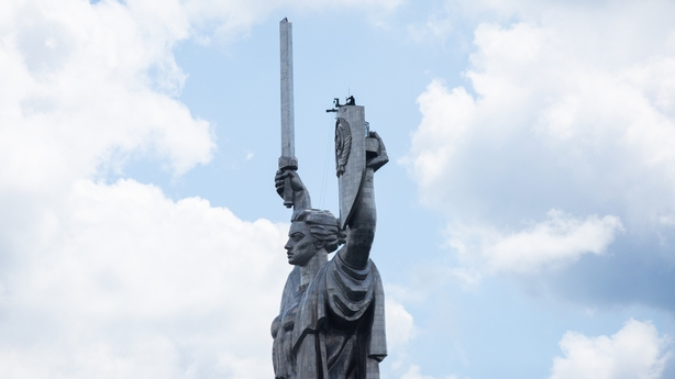 Workers removing the Russian hammer and sickle from the shield