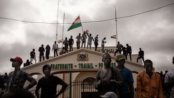 Protesters hold a Niger flag during a demonstration on independence day in Niamey last week