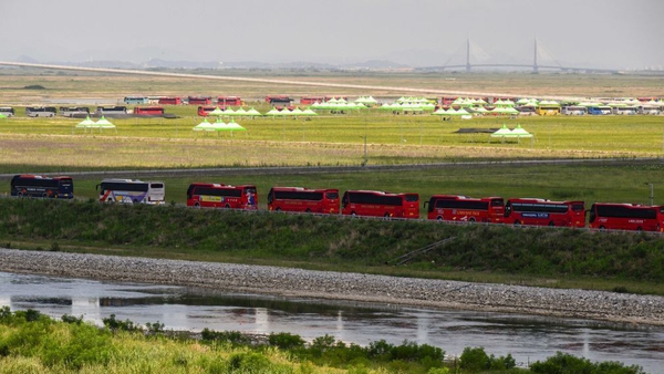 A line of coaches is seen on a road outside a campsite during preparations for scouts to leave the World Scout Jamboree