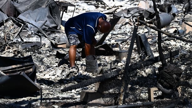 A man looks through the ashes of his family's home on Malolo Place in the aftermath of a wildfire in Lahaina