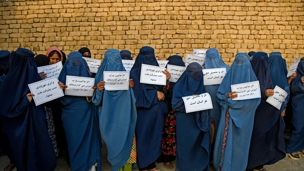 Afghan women hold placards as they protest for their right to education