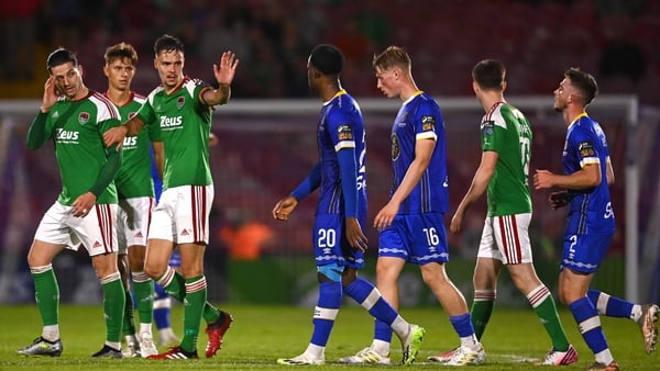 Cork City players Ruairi Keating and Cian Coleman gesture to Roland Idowu of Waterford as he leaves the pitch after being shown a red card