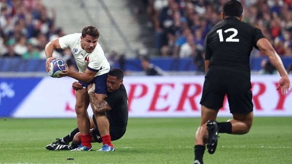 France's scrum-half and captain Antoine Dupont (L) is tackled by New Zealand's scrum-half Aaron Smith