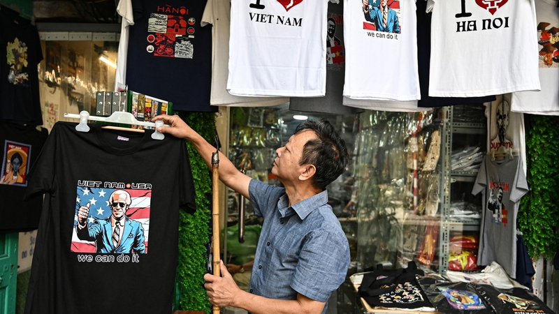 Vietnamese designer Truong Thanh Duc displays a shirt with an image of US President Joe Biden in his souvenir shop in Hano