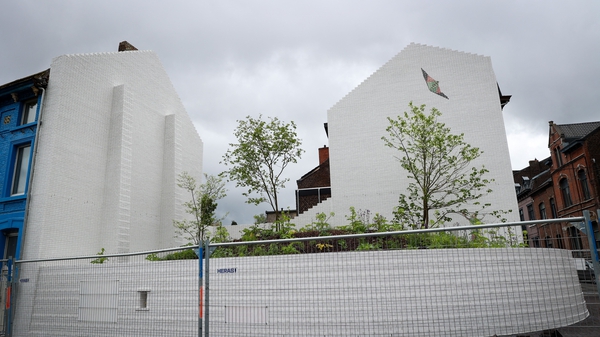 The tree-filled garden site, pictured during its construction in May, is decorated with a mural of a child watching a kite soar into the sky