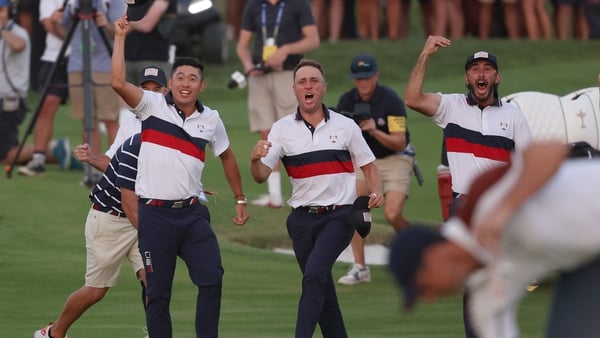 Collin Morikawa, Justin Thomas and Max Homa of Team United States celebrate on the 18th green