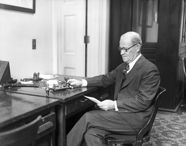 Black and white photo of a man operating a telegraph machine