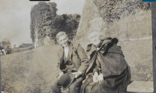 Black and white photo of a man and a woman sitting in the countryside