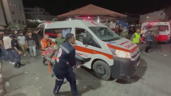 Injured people are seen being taken to hospital following this evening's air strike