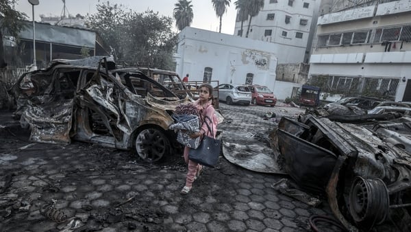 A girl tries to collect usable items from the wreckage in the grounds of Al-Ahli Hospital (Getty Images)