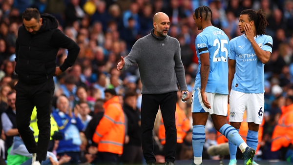 Manuel Akanji is consoled by Pep Guardiola after his red card against Brighton