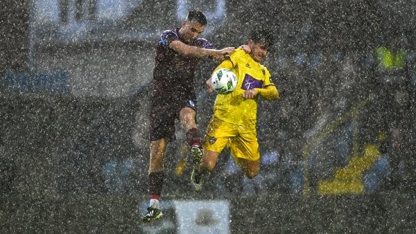 Aaron Dobbs of Wexford and Cobh's Charlie Lyons battle the elements