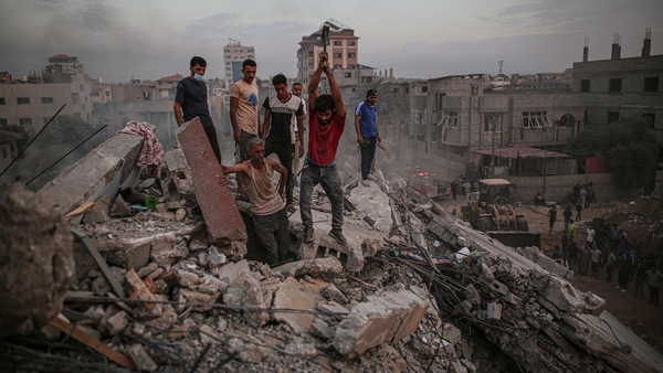 Civilians conduct a search and rescue operation under the debris of destroyed building following the Israeli attacks on the Nuseirat Camp in Deir al Balah, Gaza