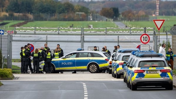 Police officers and police cars at an entrance to the runway of Hamburg Airport