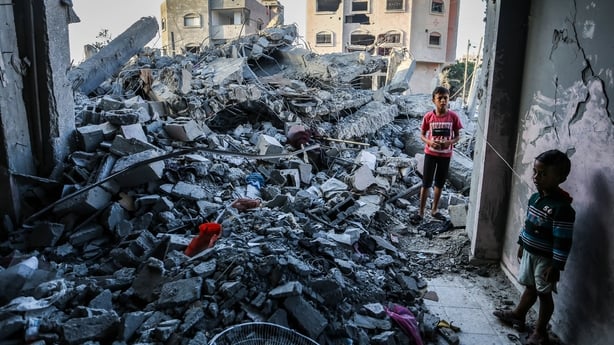 Children stand in a building, destroyed during Israeli air raids, in southern Gaza today
