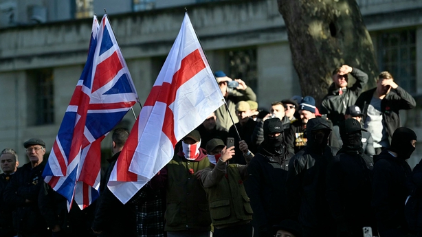 Flag waving spectators join the crowds waiting to view the two minute's silence near to the Cenotaph