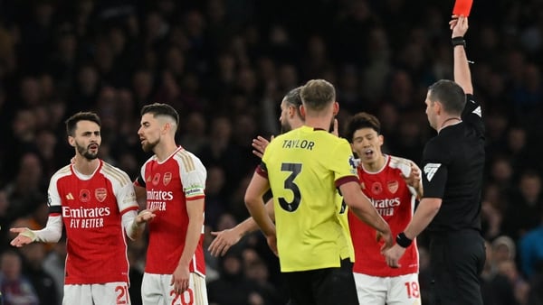 Referee Michael Oliver shows a red card to Arsenal midfielder Fabio Vieira (L)