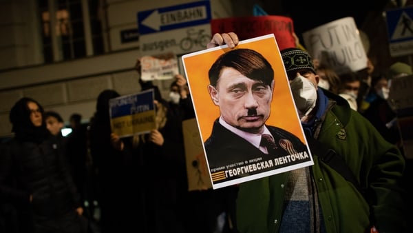 A demonstrator holds up a sign showing Russian president Vladimir Putin as Adolf Hitler during a protest in Vienna in February 2022. Photo: Thomas Kronsteiner/Getty Images