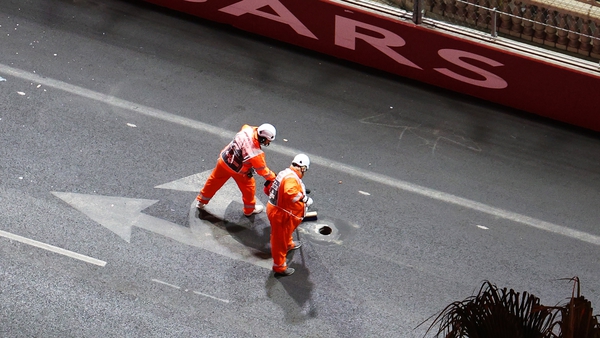 Track marshals sweep an area around the exposed drain on track