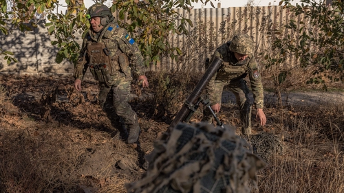 Ukrainian servicemen of the 123rd Territorial Defense Brigade in action while firing a mortar over the Dnipro River toward Russian positions