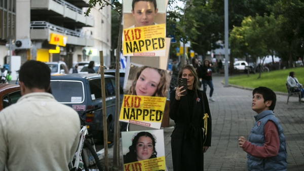 People look at signs with photos of children held hostage in Gaza Strip during a rally outside Tel Aviv's Unicef offices this afternoon