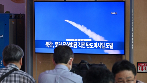 People watch file footage of a North Korean missile test, at a railway station in Seoul on 13 September