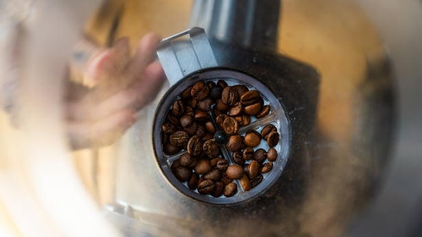 The fracturing and friction of coffee beans during grinding generates electricity that causes coffee particles to clump together and stick to the grinder
