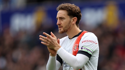 Tom Lockyer, jogador do Luton Town, reage após sofrer uma paragem  cardíaca no relvado