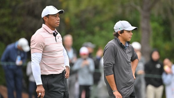 Tiger Woods and his son, Charlie Woods, stand together on the ninth green during the first round