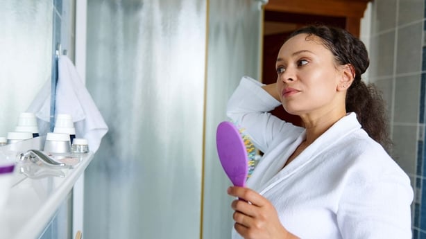 A woman brushing her hair in the bathroom