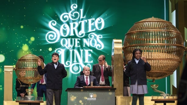 upils of the San Ildefonso school hold the lottery balls revealing the top prize winning number