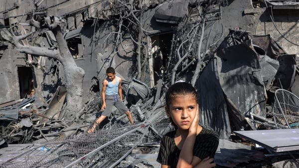 A girl looks on as she stands by the rubble outside a building that was hit by Israeli bombardment in Rafah in southern Gaza on 31 October