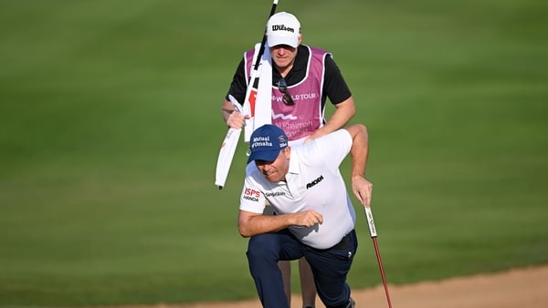 Padraig Harrington and his caddie Ronan Flood line up a putt on the 12th