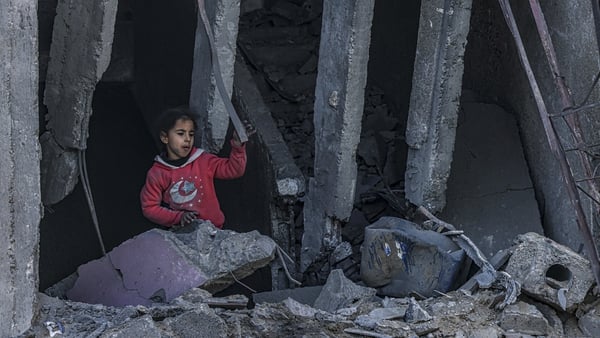 A Palestinian child stands amid the rubble of a building where two hostages were reportedly held before being rescued during an operation by Israeli security forces in Rafah